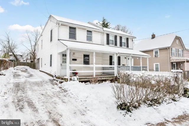 a front view of a house with a yard covered in snow