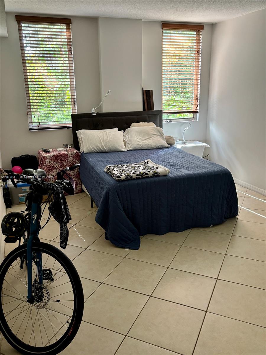 2630 Southwest 28th Street, Unit 34 Miami, FL 33133 - Photo 14 of 26 a bedroom with a bed and a table