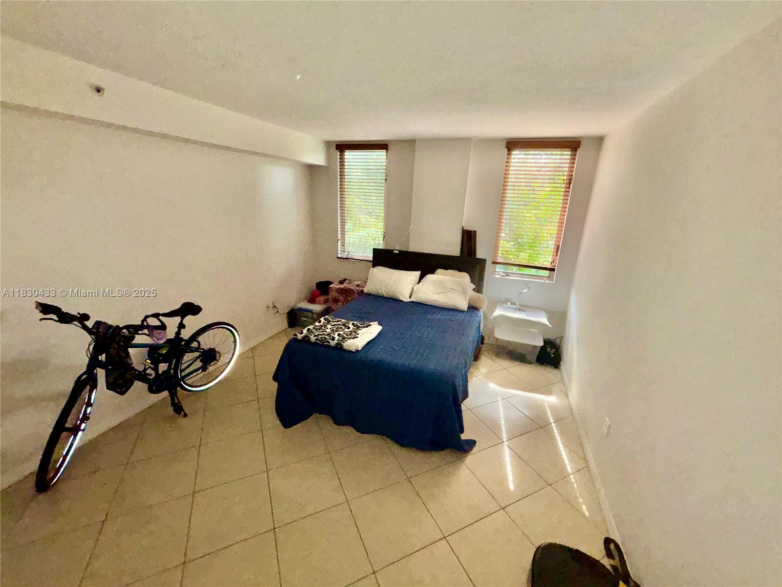 2630 Southwest 28th Street, Unit 34 Miami, FL 33133 - Photo 16 of 26 a living room with furniture gym equipment and a window