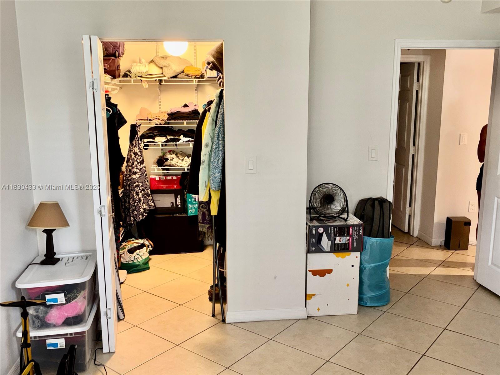 2630 Southwest 28th Street, Unit 34 Miami, FL 33133 - Photo 17 of 26 a hallway with a view of kitchen appliances and a chandelier