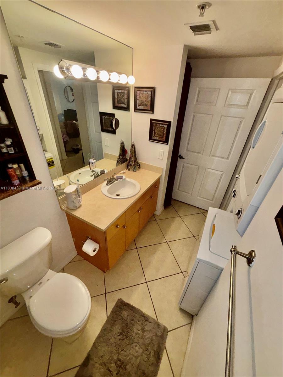 2630 Southwest 28th Street, Unit 34 Miami, FL 33133 - Photo 21 of 26 a bathroom with a sink mirror and toilet
