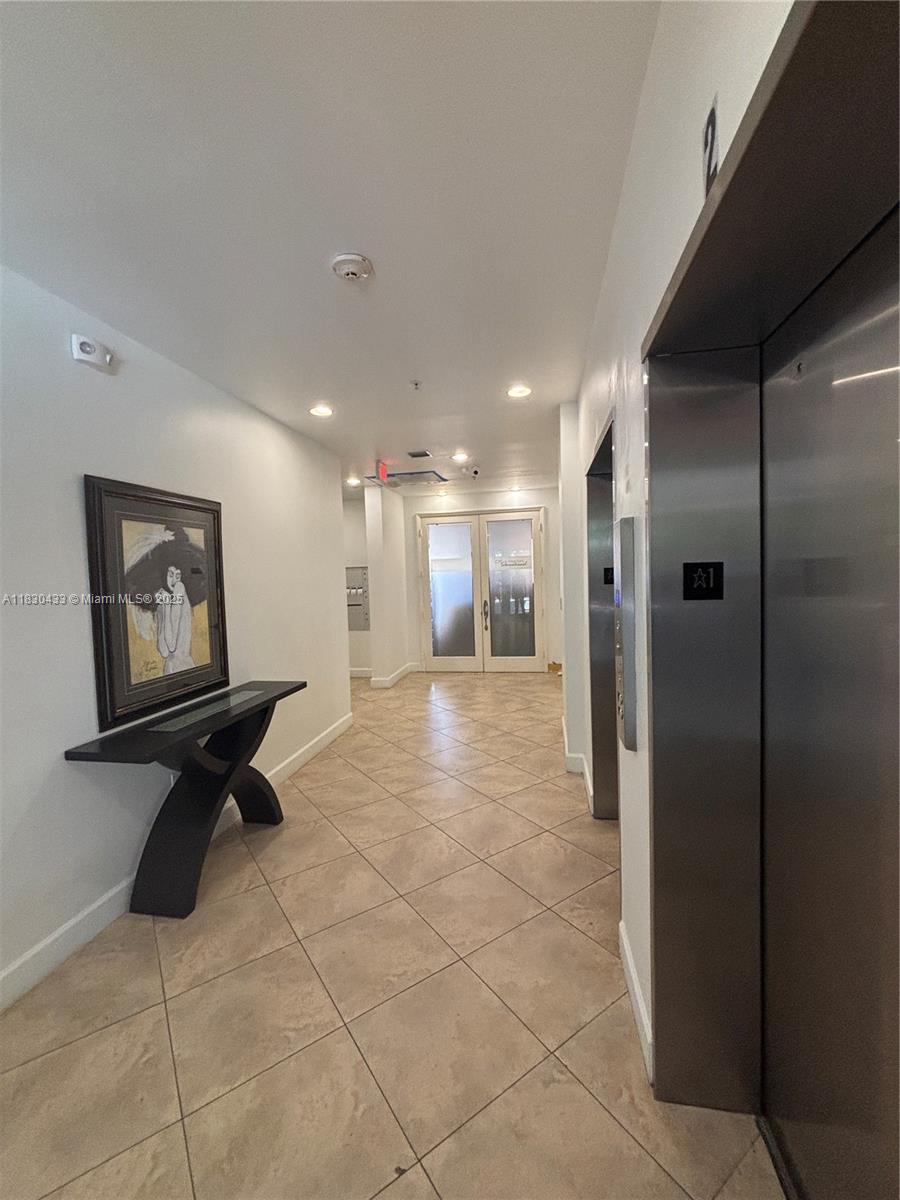 2630 Southwest 28th Street, Unit 34 Miami, FL 33133 - Photo 6 of 26 a view of a hallway with a table and chairs