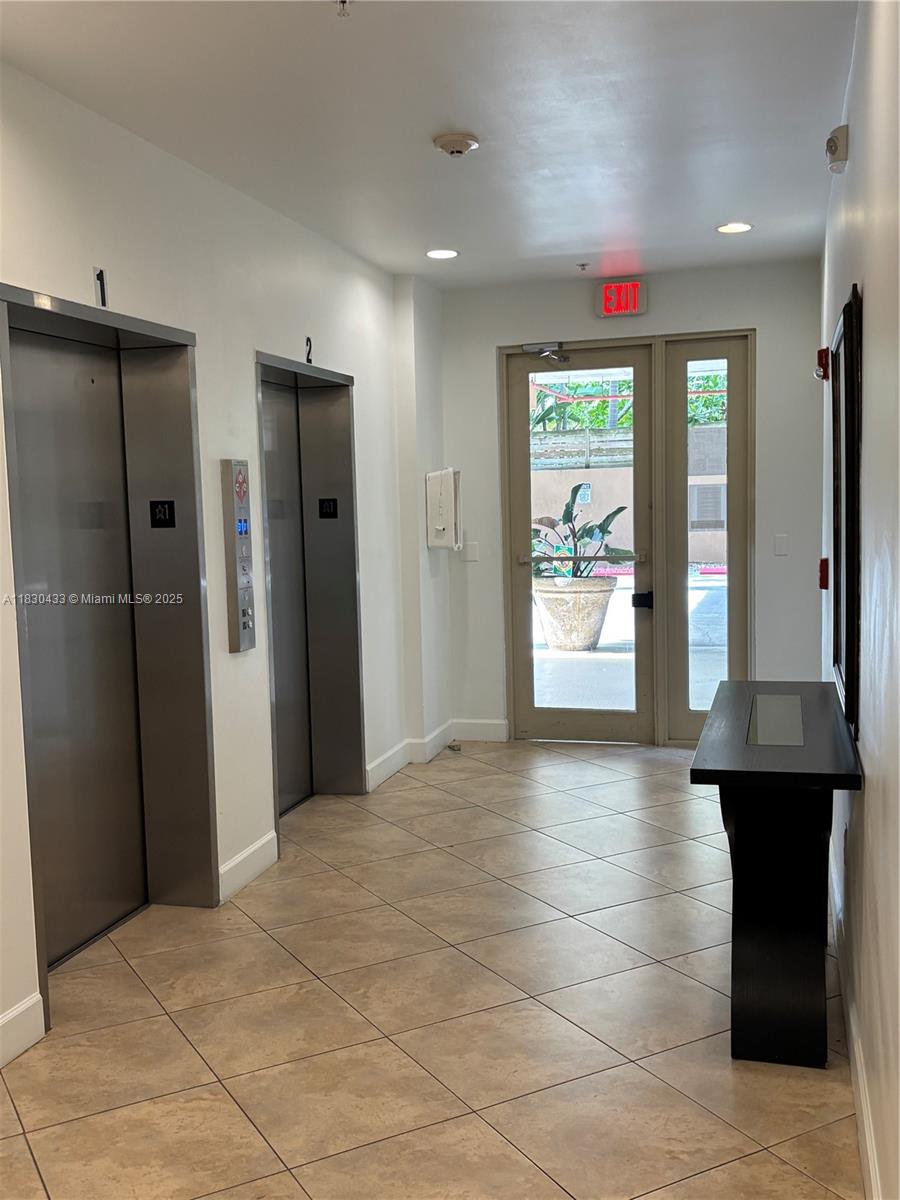 2630 Southwest 28th Street, Unit 34 Miami, FL 33133 - Photo 7 of 26 a view of a hallway with wooden shelves