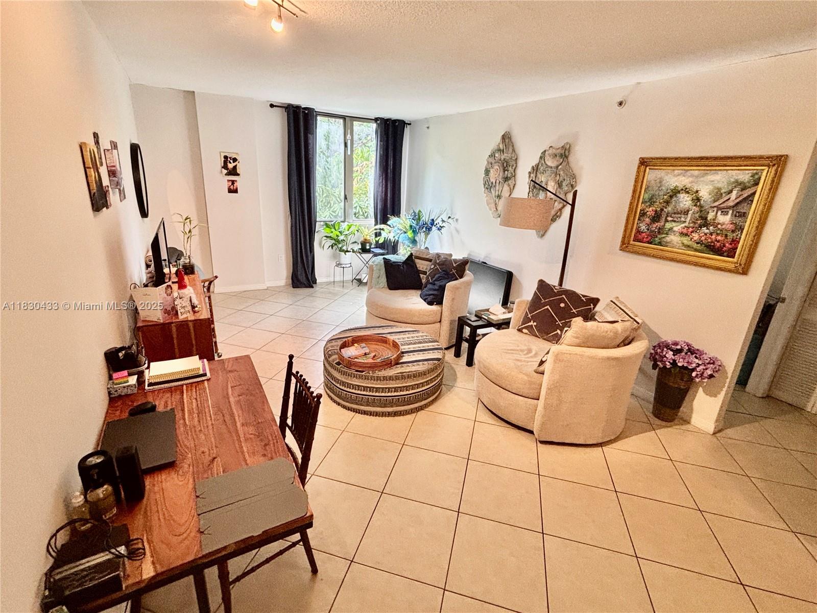 2630 Southwest 28th Street, Unit 34 Miami, FL 33133 - Photo 10 of 26 a living room with furniture and a flat screen tv