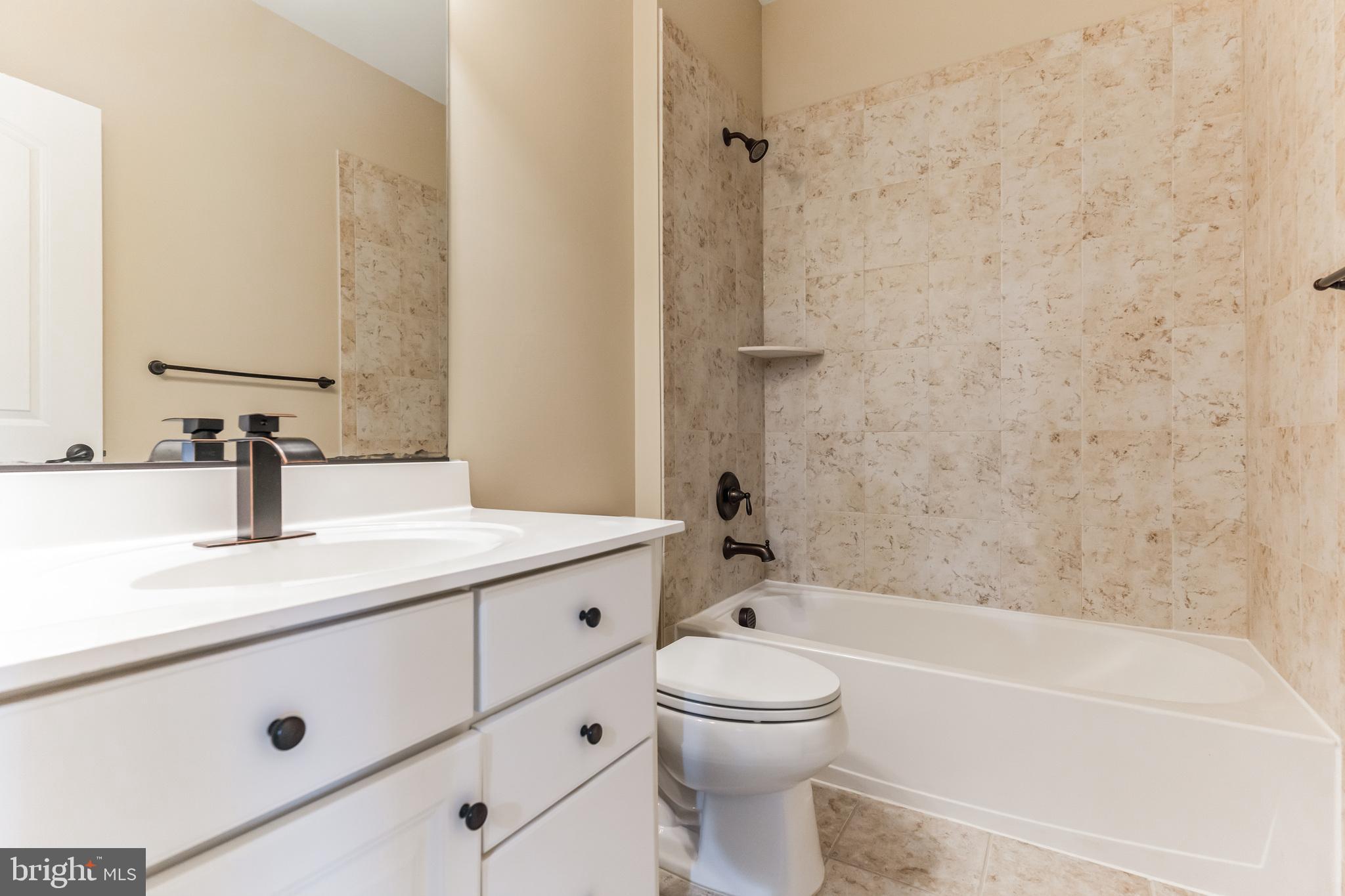 4927 Collingtons Bounty Drive Bowie, MD 20720 - Photo 35 of 38 a bathroom with a granite countertop sink a toilet and bathtub