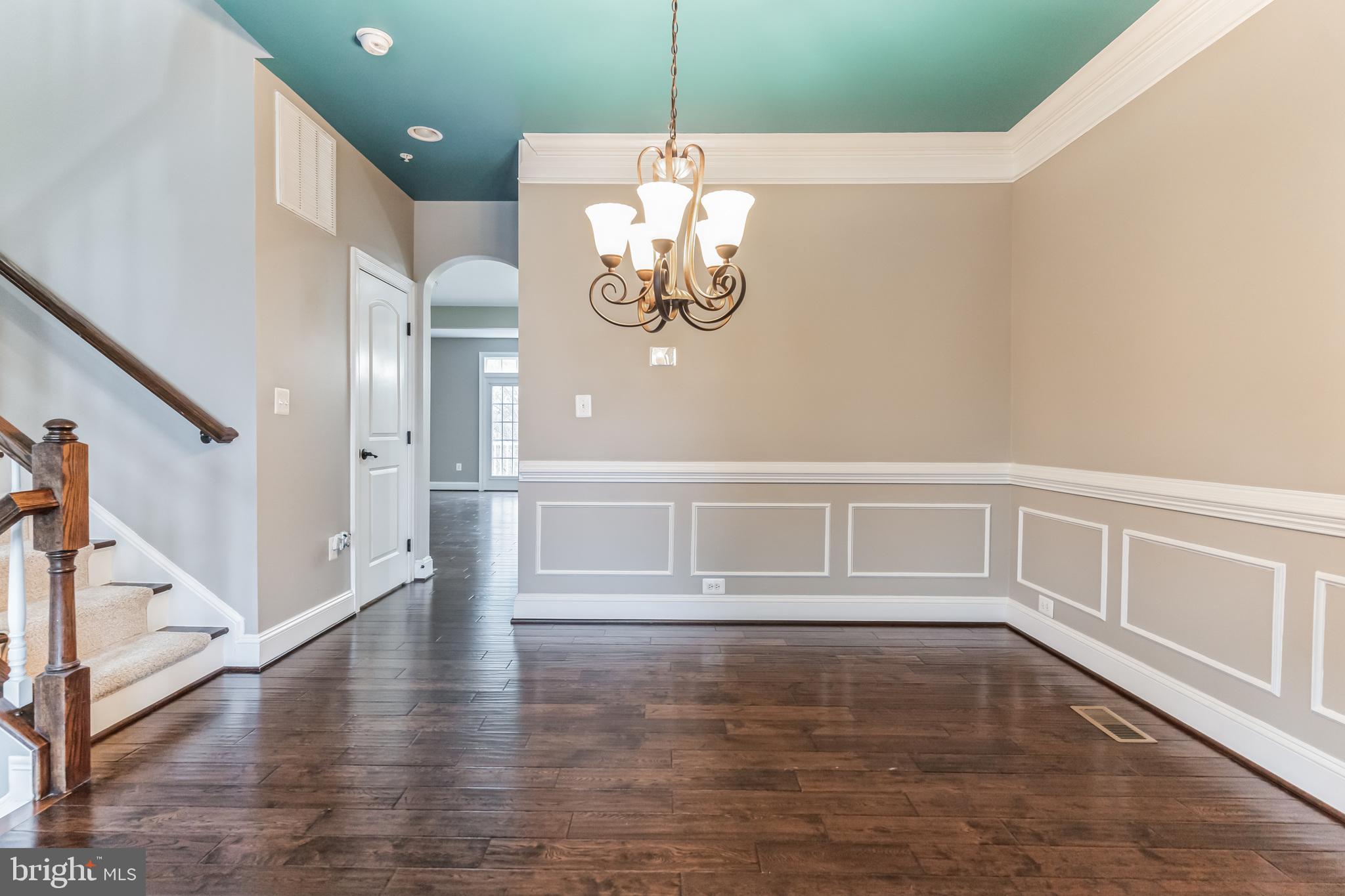 4927 Collingtons Bounty Drive Bowie, MD 20720 - Photo 9 of 38 a view of an empty room with wooden floor and stairs