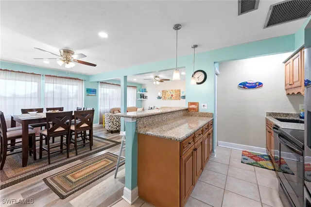 a kitchen with stainless steel appliances granite countertop a sink a stove and a wooden cabinets