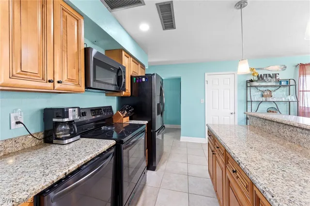 a kitchen with stainless steel appliances granite countertop a refrigerator and a stove top oven