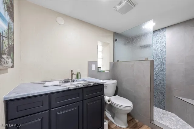 a bathroom with a granite countertop toilet sink and mirror