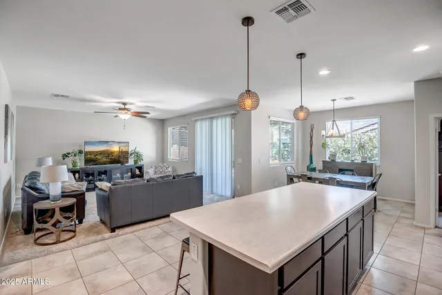 a kitchen with kitchen island a counter space dining table and a large window