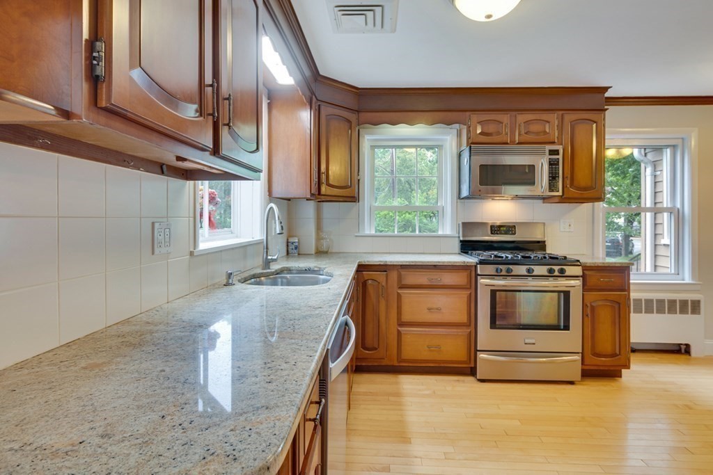 65 Longfellow Road Newton, MA 02462 - Photo 16 of 38 a kitchen with stainless steel appliances granite countertop a stove a sink and a microwave