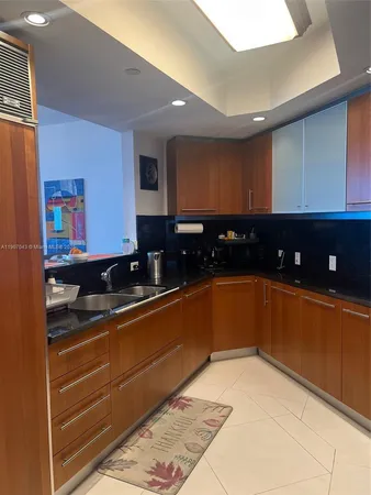 a kitchen with granite countertop sink and cabinets