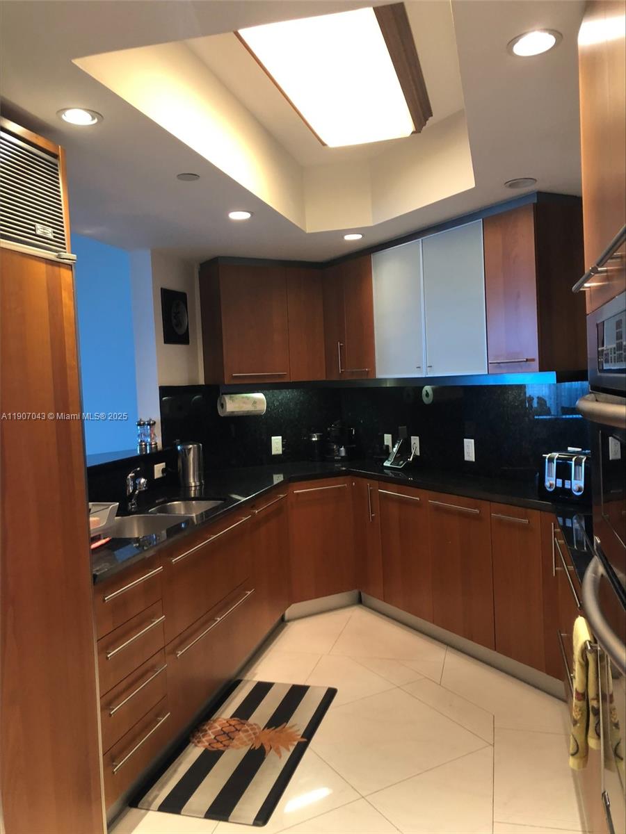 9401 Collins Avenue, Unit 801 Surfside, FL 33154 - Photo 12 of 51 a kitchen with stainless steel appliances granite countertop a sink and cabinets