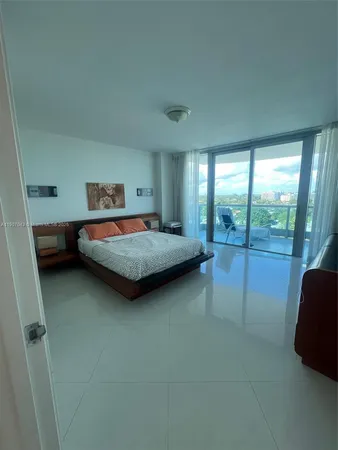 a bedroom with a bed and large window