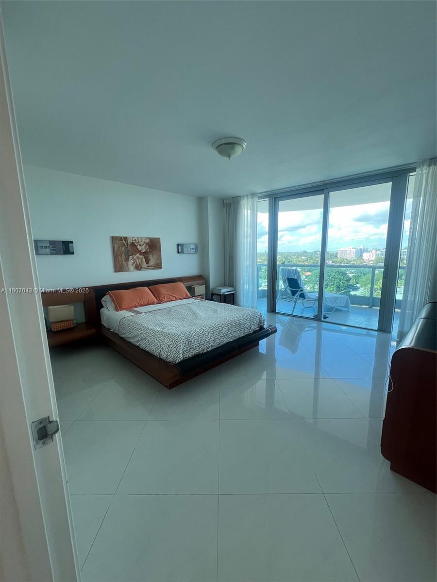 9401 Collins Avenue, Unit 801 Surfside, FL 33154 - Photo 13 of 51 a bedroom with a bed and large window