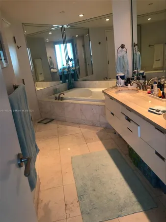 a spacious bathroom with a tub sink and mirror