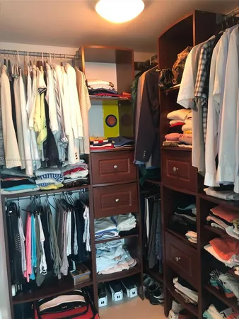 a view of walk in closet with clothes and shoes