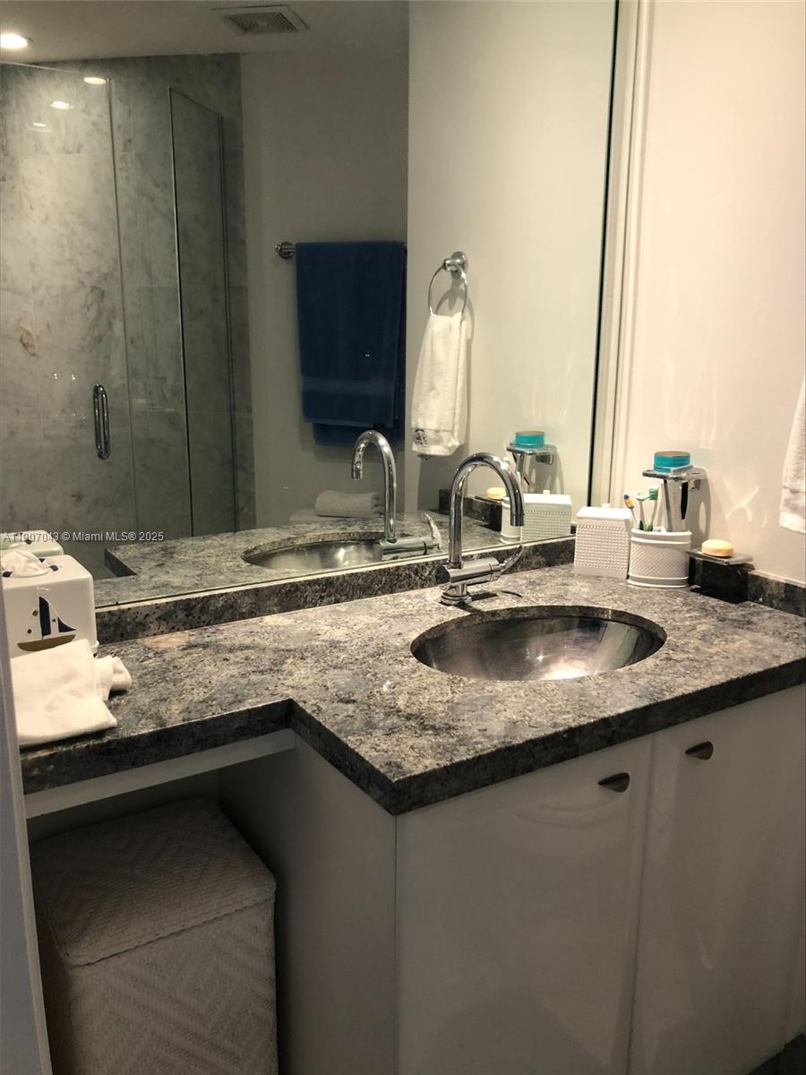 9401 Collins Avenue, Unit 801 Surfside, FL 33154 - Photo 21 of 51 a bathroom with a granite countertop sink and a mirror
