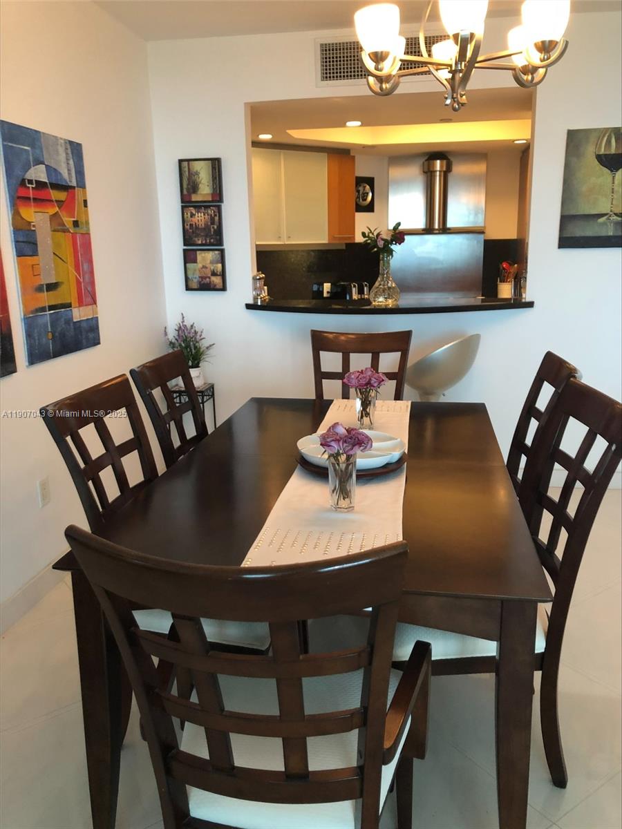 9401 Collins Avenue, Unit 801 Surfside, FL 33154 - Photo 3 of 51 a view of a dining room with furniture and wooden floor