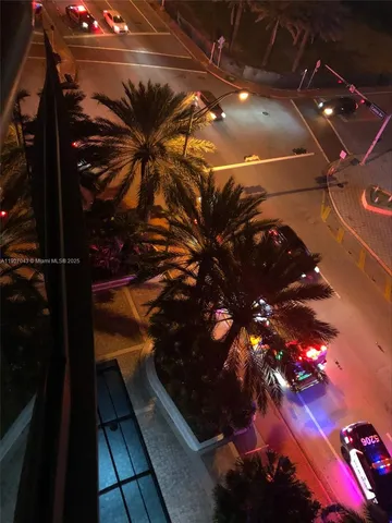 a front view of a multi story building with yard and parking space