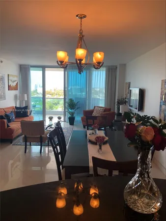 a living room with furniture a floor to ceiling window and rug