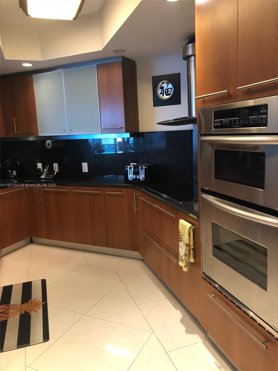 9401 Collins Avenue, Unit 801 Surfside, FL 33154 - Photo 9 of 51 a kitchen with granite countertop a stove and a microwave