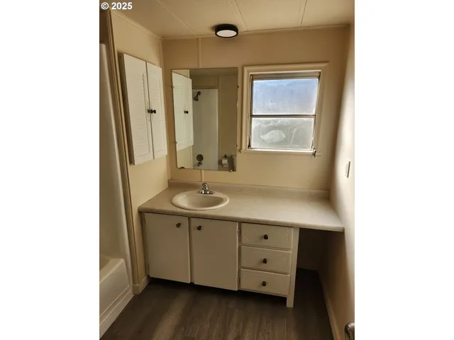 a bathroom with a sink mirror and window