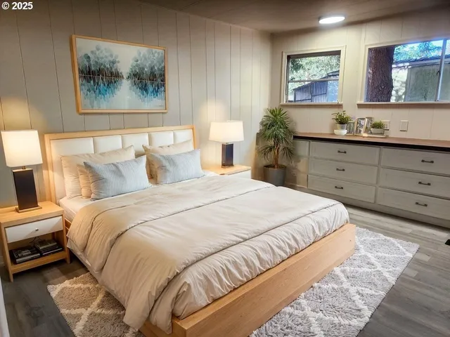 a bedroom with a bed and a painting on the wall