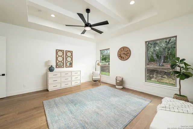 a view of a livingroom with a ceiling fan and wooden floor