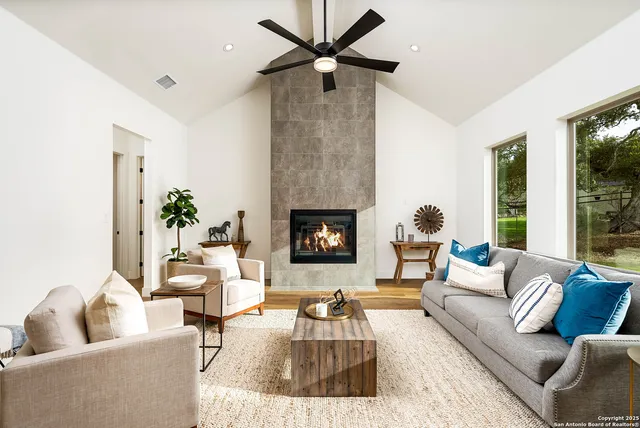 a living room with furniture a fireplace and a chandelier