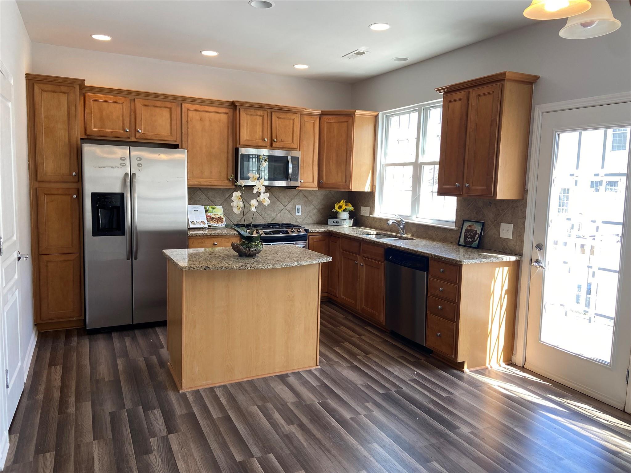 722 Passage Drive Fort Mill, SC 29708 - Photo 7 of 13 a kitchen with stainless steel appliances granite countertop a stove a sink dishwasher a refrigerator and a microwave oven with wooden floor