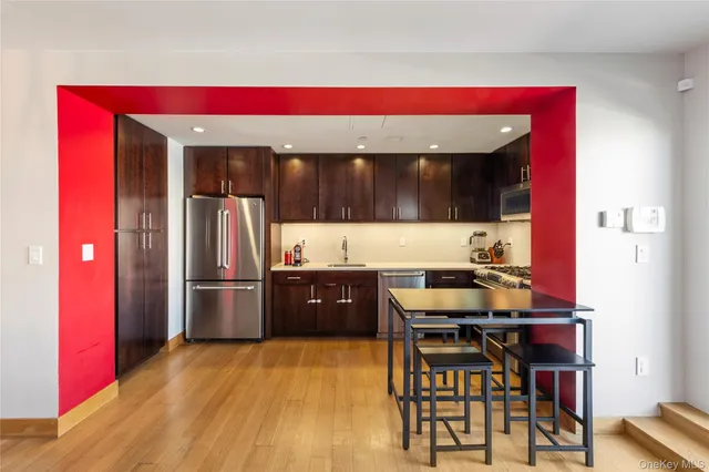 a living room with stainless steel appliances kitchen island granite countertop furniture and wooden floor