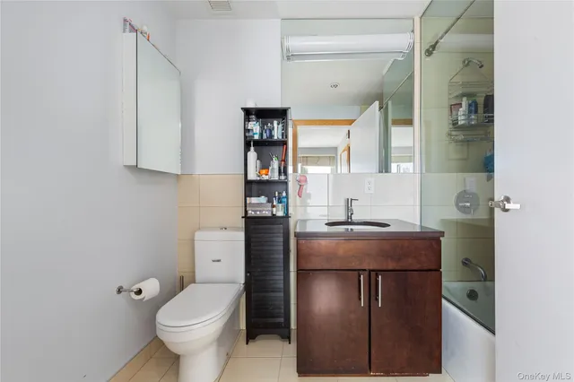 a bathroom with a granite countertop toilet a sink and a mirror