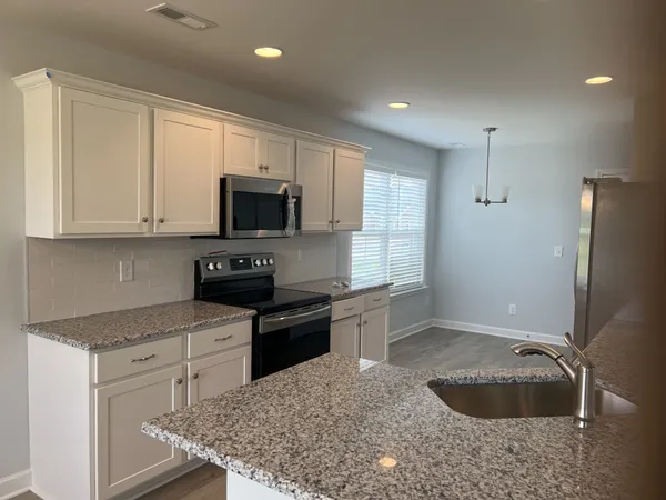 a kitchen with granite countertop a cabinets and steel appliances