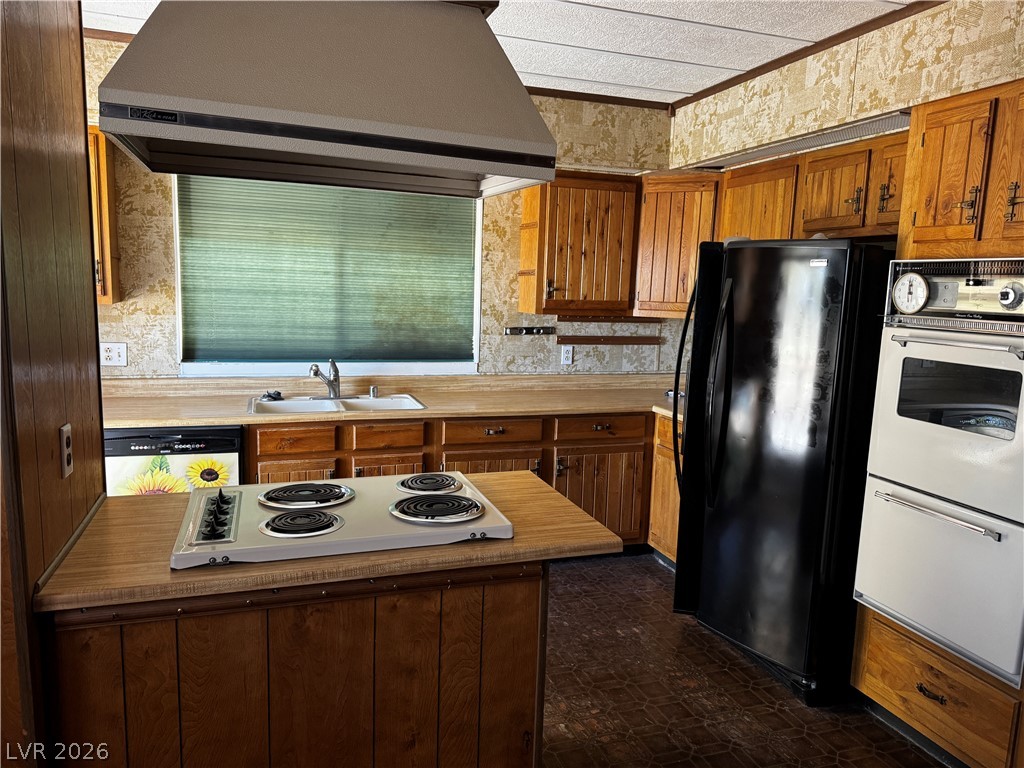 3090 Gally Road Pahrump, NV 89060 - Photo 9 of 20 A functional kitchen features wood cabinetry and a classic electric range with an integrated hood.