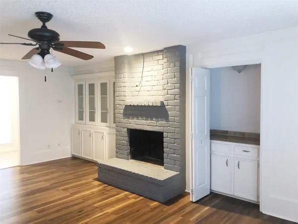 a view of an empty room with a fireplace and a window