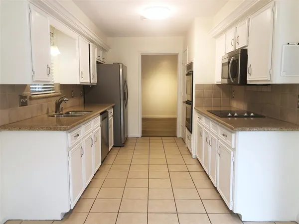a kitchen with stainless steel appliances a sink stove and refrigerator