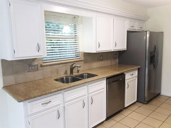 a kitchen with granite countertop white cabinets and white appliances
