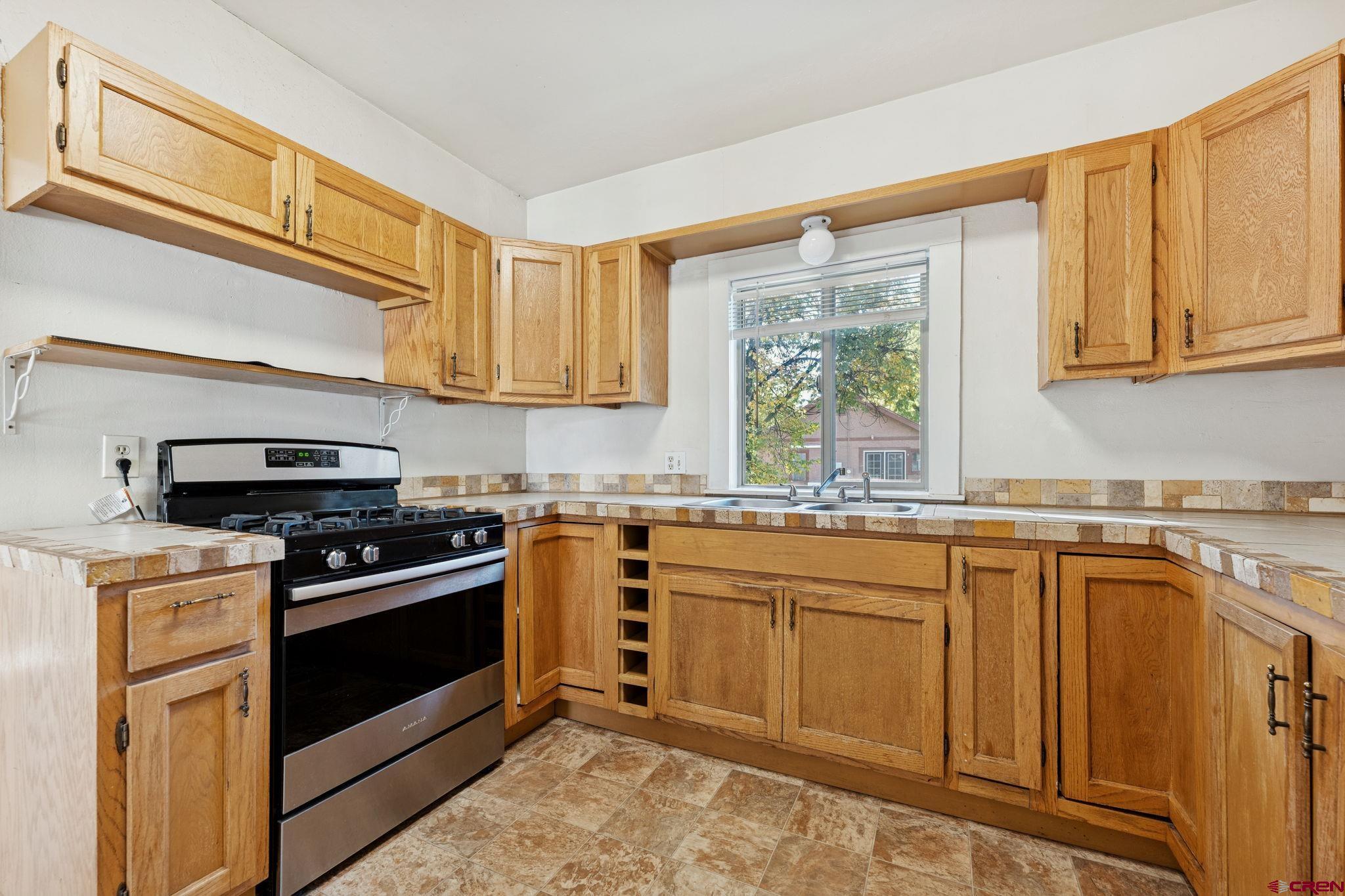 1840 West 3rd Avenue Durango, CO 81301 - Photo 17 of 32 a kitchen with stainless steel appliances granite countertop a stove a sink and a microwave
