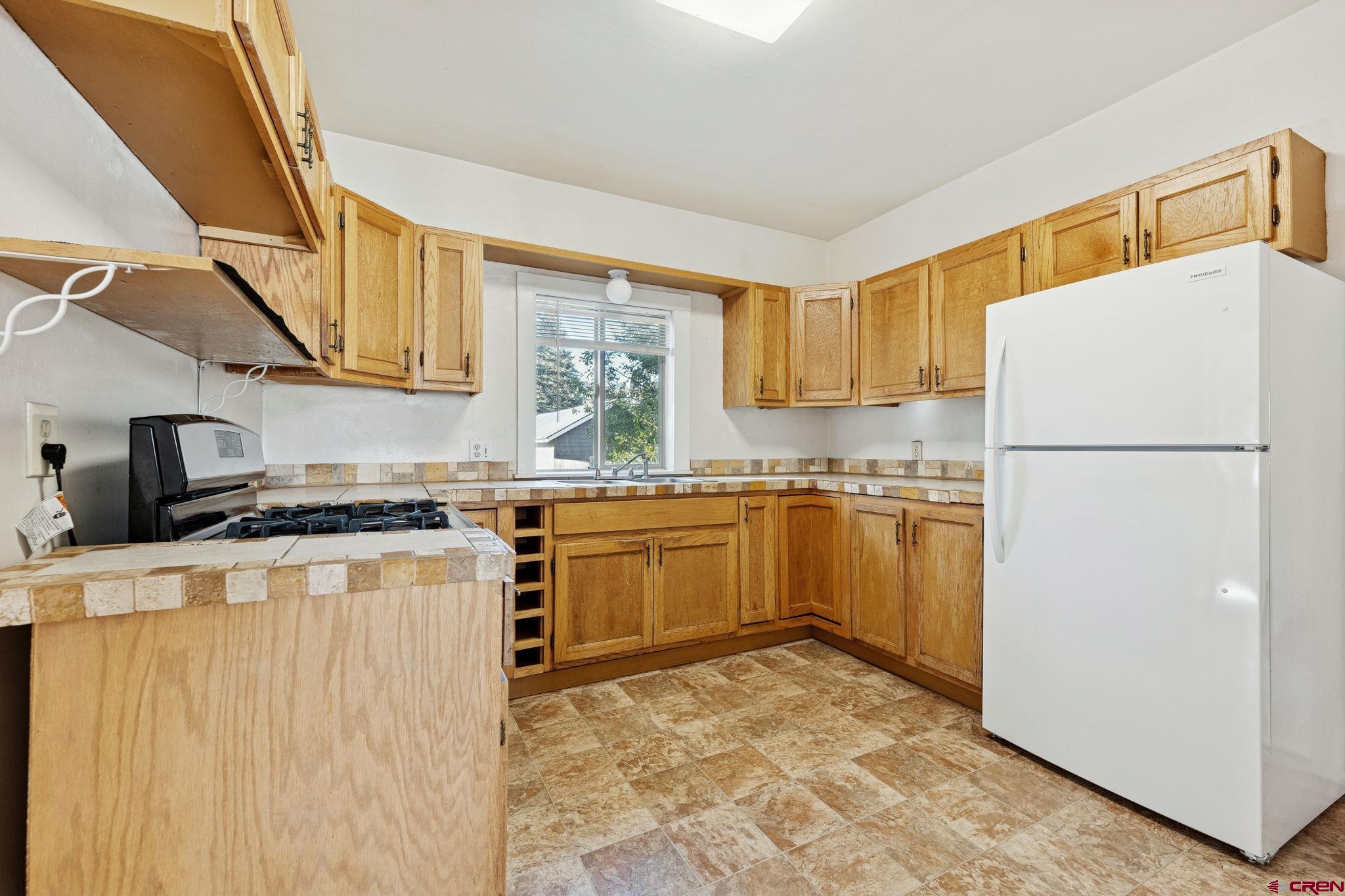 1840 West 3rd Avenue Durango, CO 81301 - Photo 17 of 33 a kitchen with a refrigerator sink stove and a window