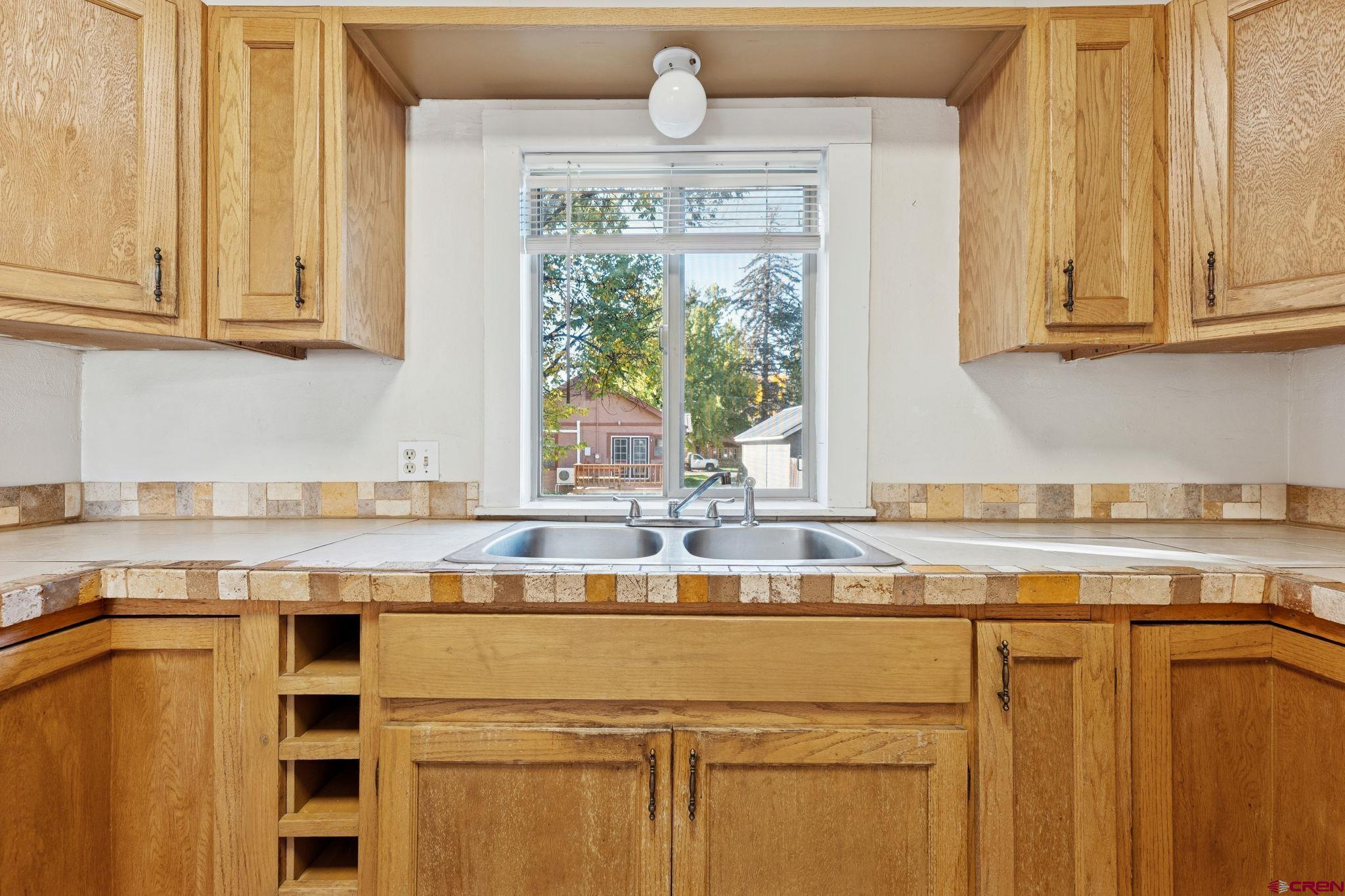1840 West 3rd Avenue Durango, CO 81301 - Photo 18 of 32 a kitchen with stainless steel appliances granite countertop a sink window and cabinets