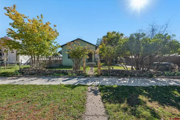 a view of a house with a yard and tree s
