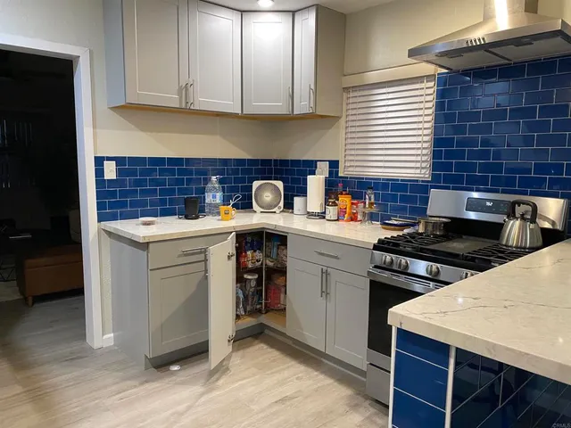 a kitchen with a stove a sink a refrigerator and cabinets
