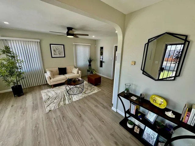 a living room with furniture and a wooden floor