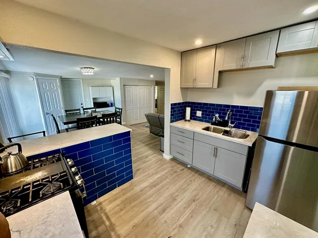 a kitchen with a refrigerator and a stove top oven