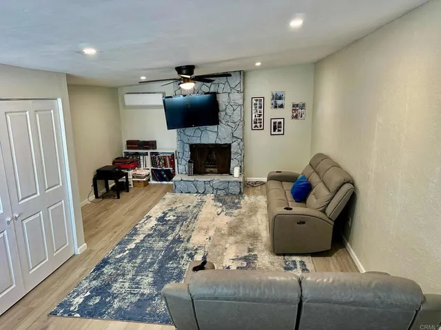 a living room with furniture a flat screen tv and a fireplace