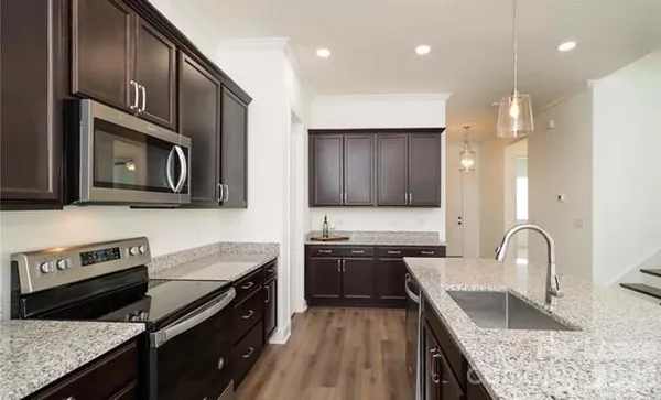 a kitchen with stainless steel appliances granite countertop wooden cabinets sink and stove