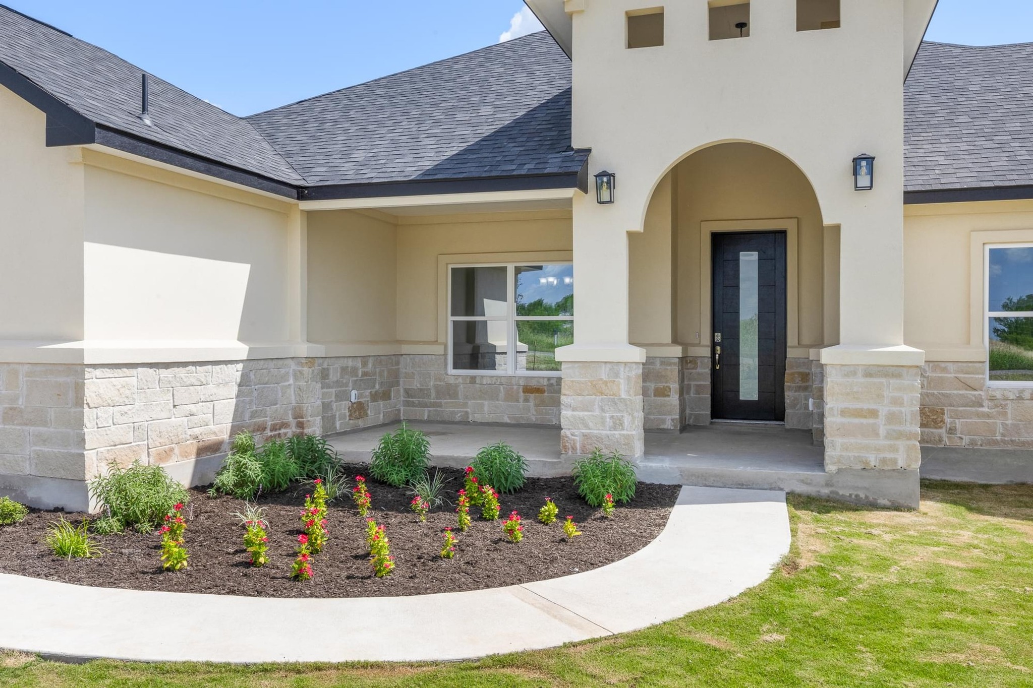 1136 County Road 484 Elgin, TX 78621 - Photo 3 of 37 Property entrance with stone siding, a shingled roof, stucco siding, and a yard