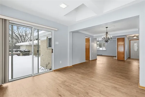 a view of a big room with wooden floor and windows