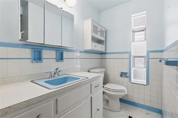 a bathroom with a sink a toilet and mirror